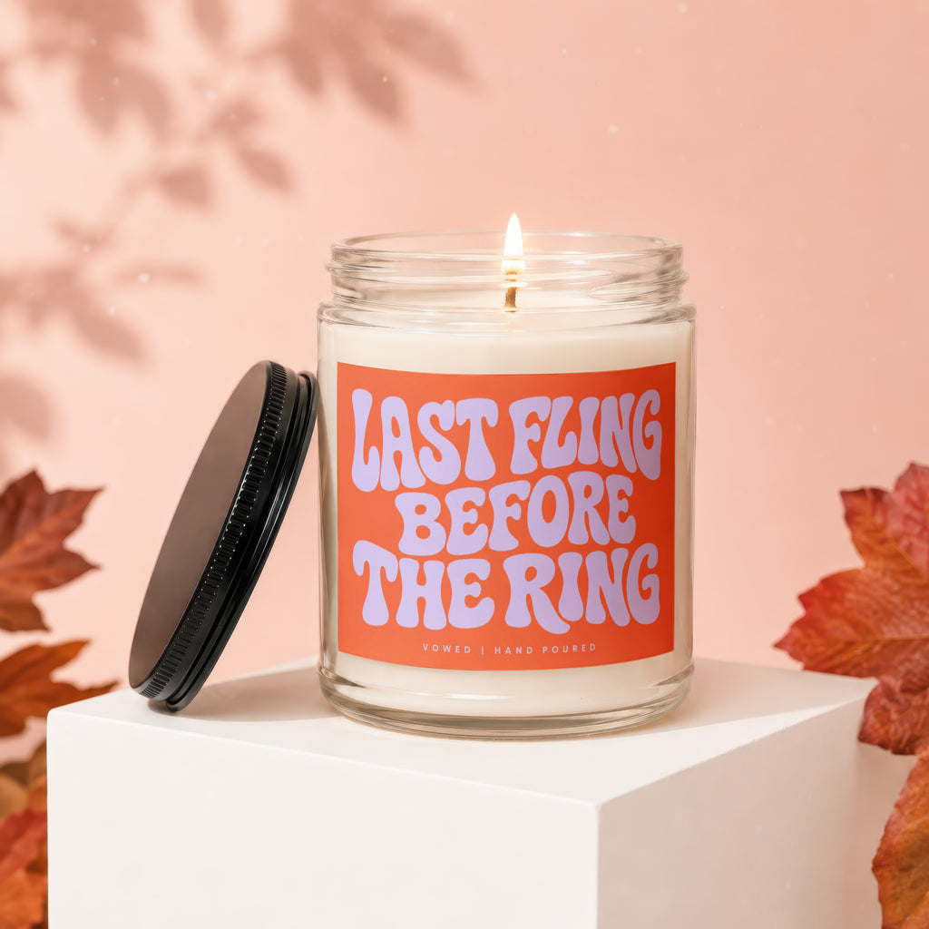 Candle with orange label saying "LAST FLING BEFORE THE RING" and "VOWED | HAND POURED".