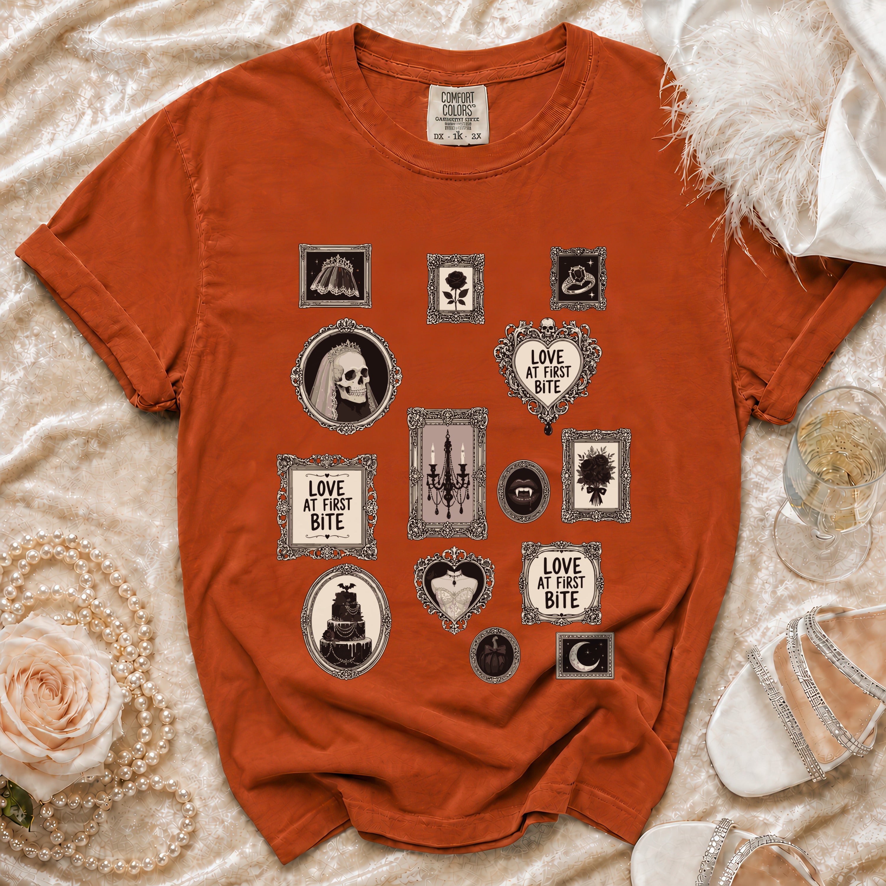 Orange t-shirt with framed gothic motifs including skulls, roses, and the text "Love at First Bite".