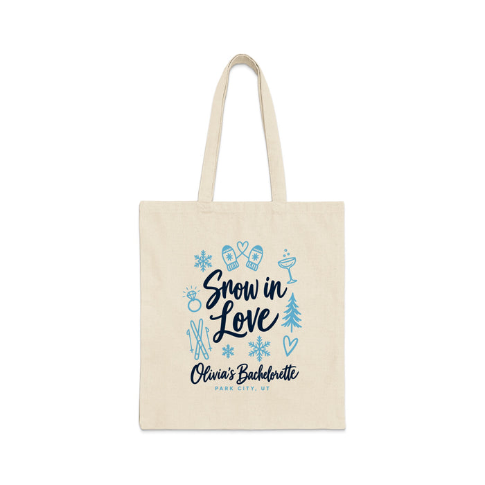 A beige canvas tote bag features blue graphics and text that reads Snow in Love, Olivia's Bachelorette, Park City, UT.