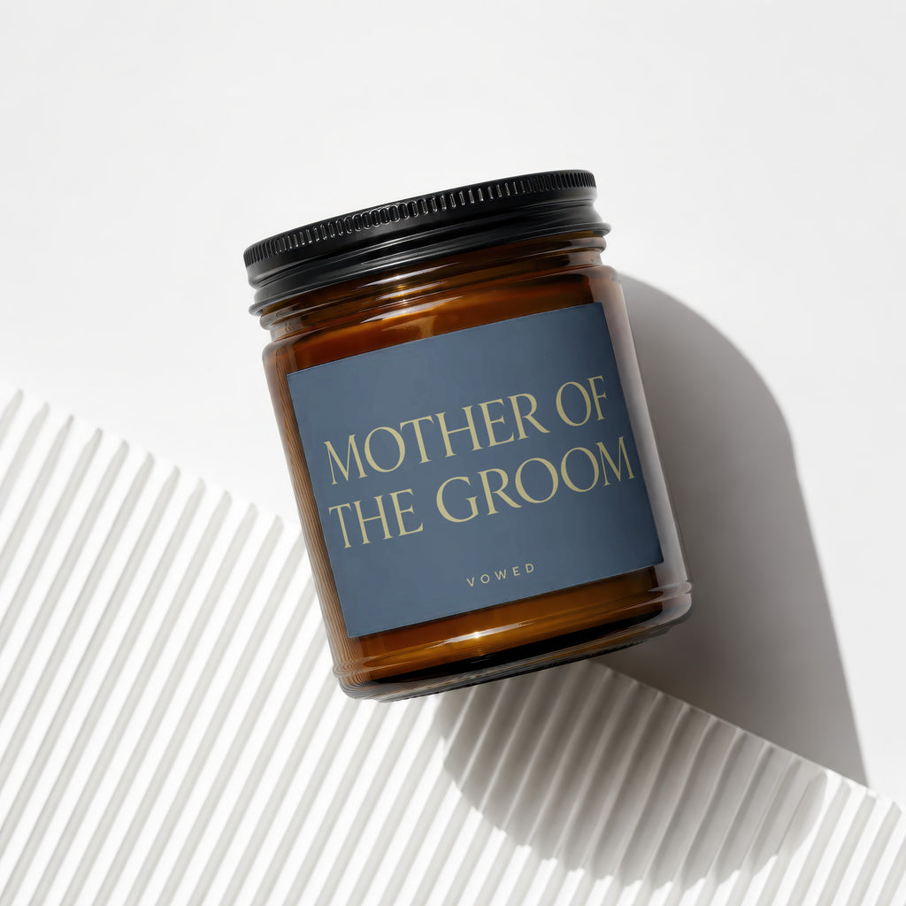 Amber candle in glass jar with black lid, label reads "MOTHER OF THE GROOM".