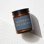 Amber candle in glass jar with black lid, label reads "MOTHER OF THE GROOM".