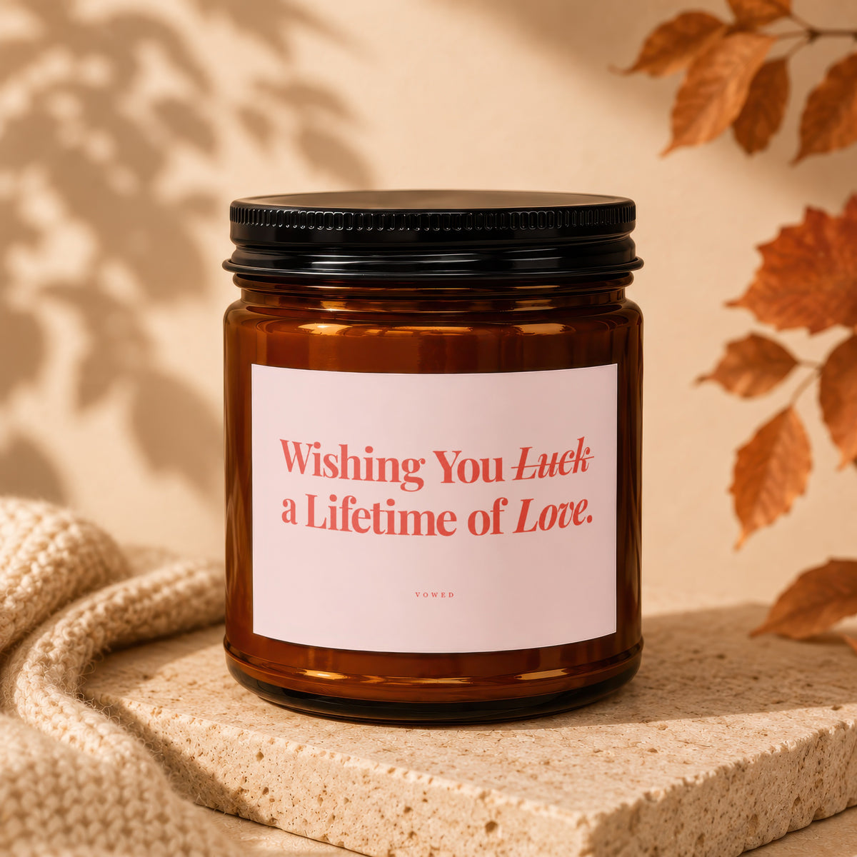 Amber candle with black lid, pink label reading "Wishing You Luck a Lifetime of Love."