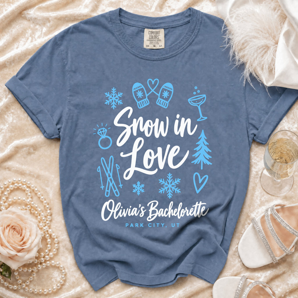Blue Comfort Colors t-shirt printed with white and light blue winter icons, "Snow in Love", and "Olivia's Bachelorette Park City, UT".