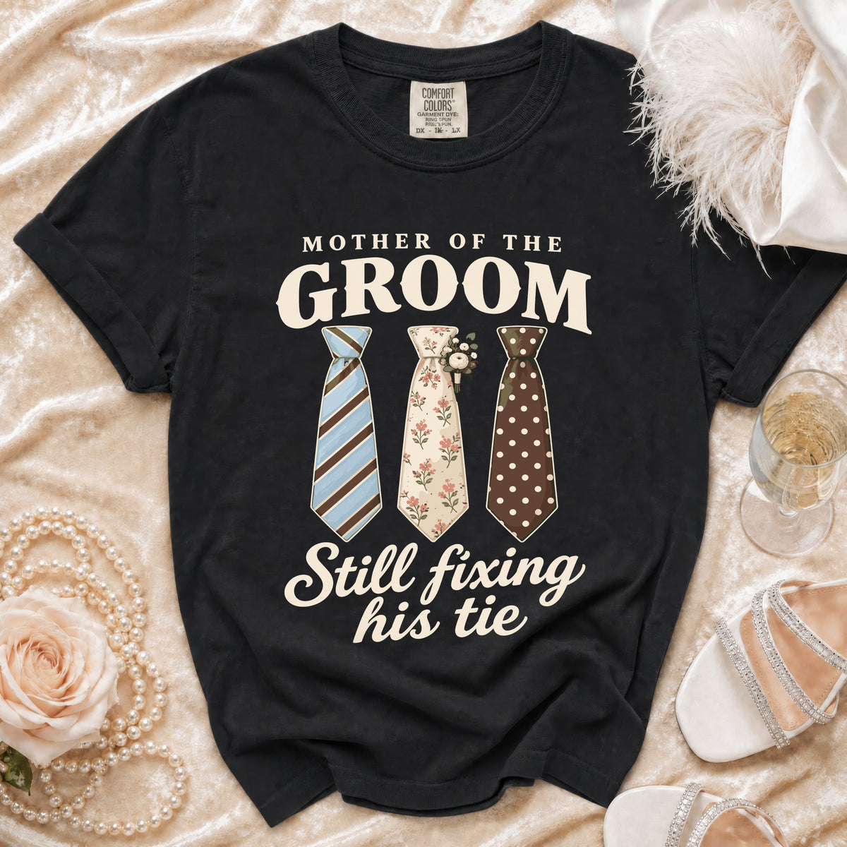 Black Comfort Colors t-shirt with "Mother of the Groom Still Fixing His Tie" text and three ties.
