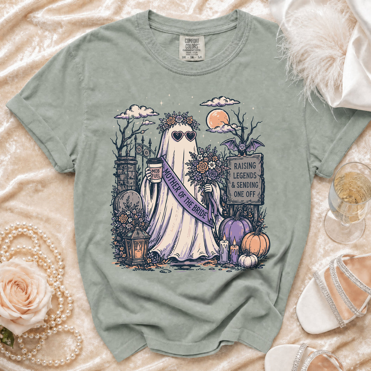 Ghost wearing "Mother of the Bride" sash, holding coffee, with Halloween-themed graveyard graphic.