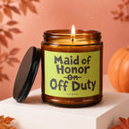 Amber jar candle with lit flame, reads "Maid of Honor on Off Duty".