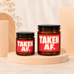 Two amber jars with black lids and red labels reading "TAKEN AF. VOWED".