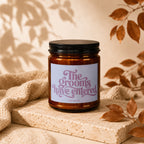Amber candle with a black lid and a label reading "The grooms have entered."