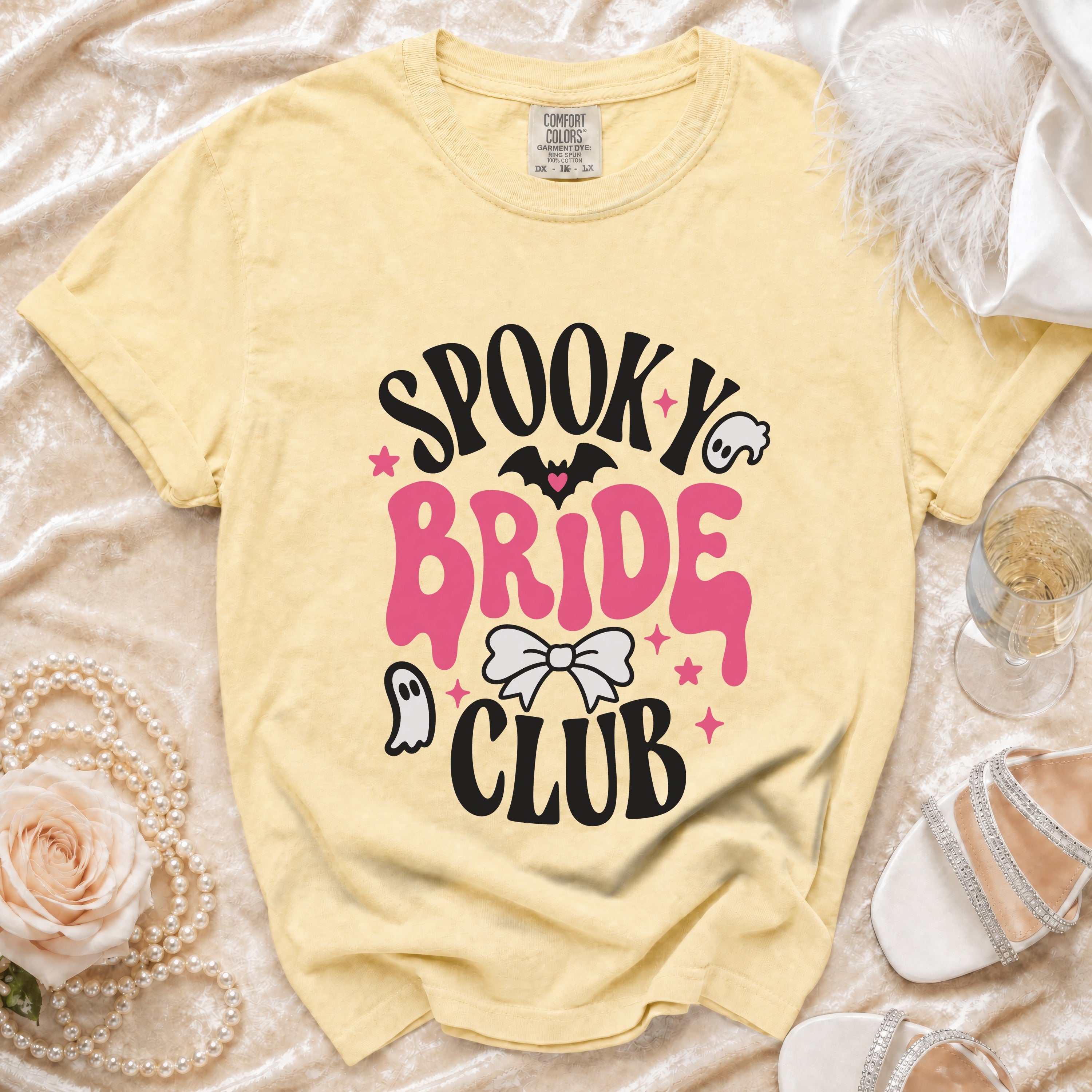 Yellow t-shirt with "Spooky Bride Club" graphic featuring bats, ghosts, and a bow.
