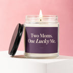 Candle with text "Two Moms. One Lucky Me." on purple label.