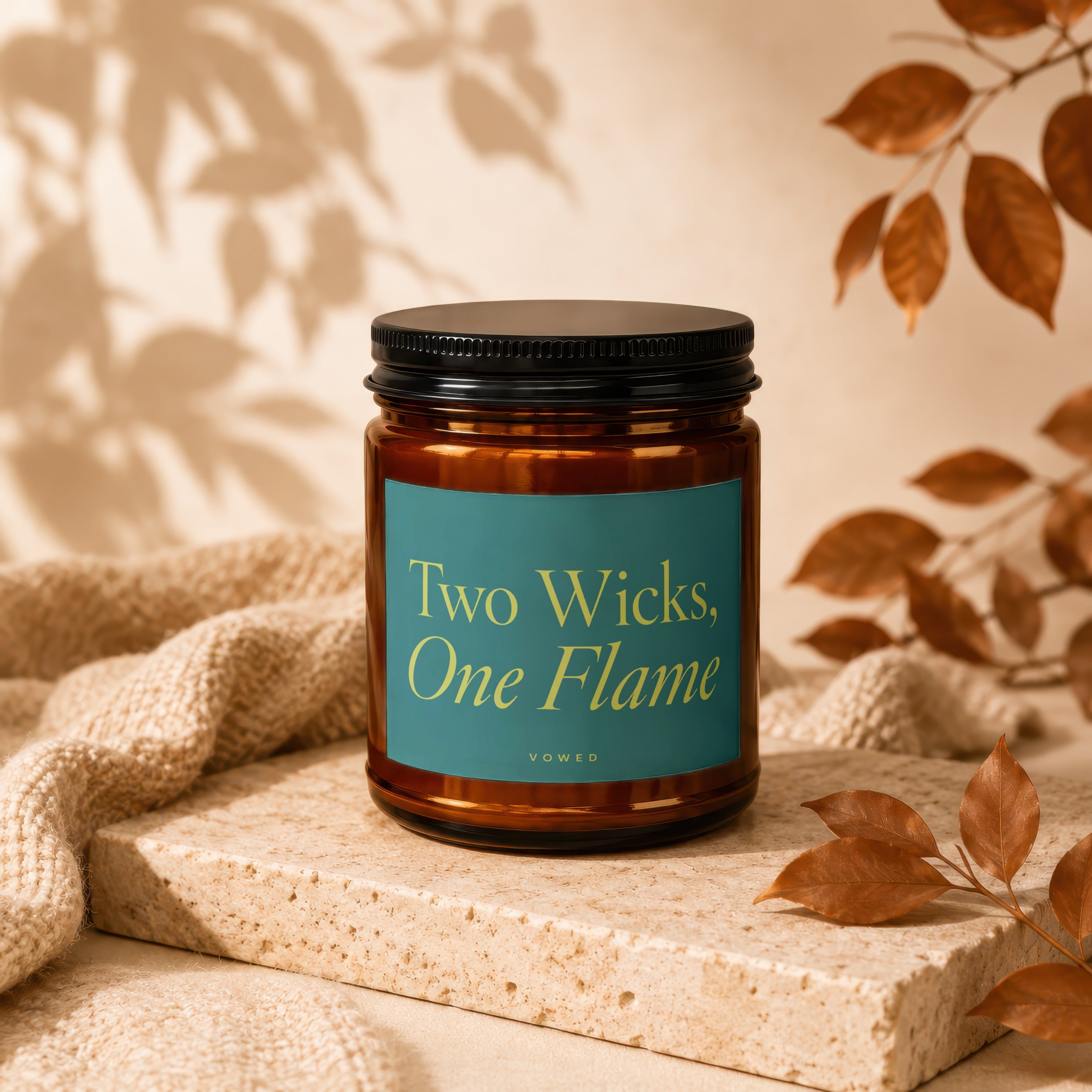 Amber candle with teal label reading "Two Wicks, One Flame" and "vowed".