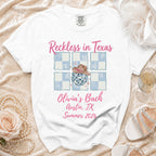 White t-shirt with "Reckless in Texas Olivia's Bach Austin, TX Summer 2026" graphic.
