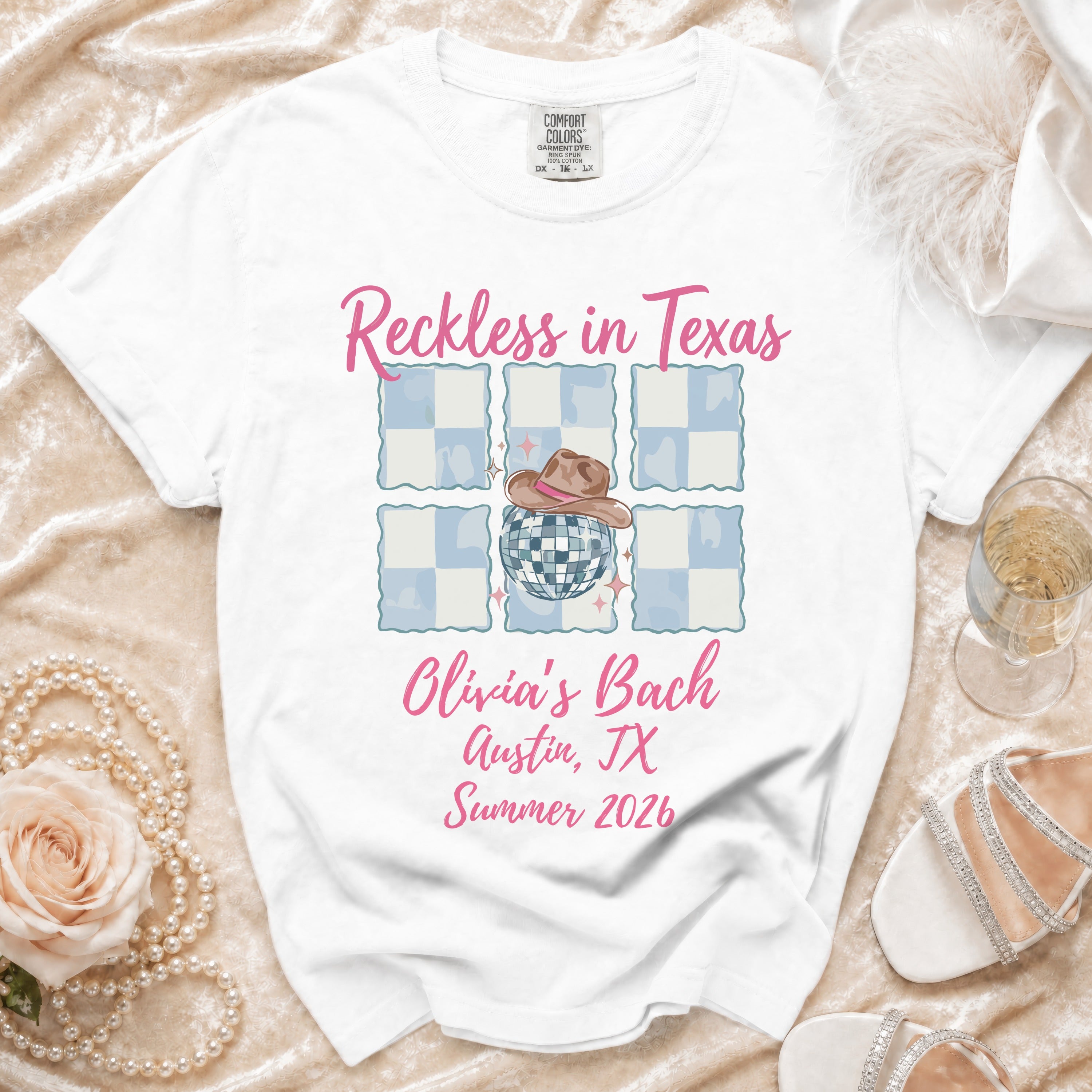 White t-shirt with "Reckless in Texas Olivia's Bach Austin, TX Summer 2026" graphic.