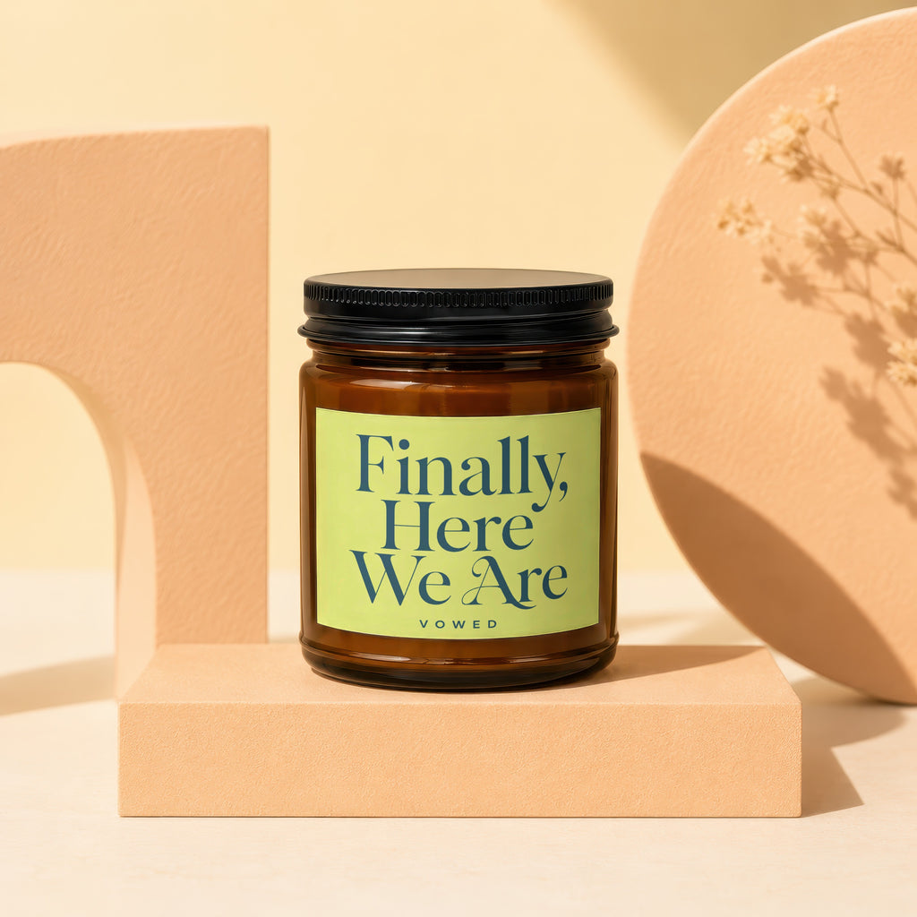 Amber jar candle with light green label reading "Finally, Here We Are Vowed".