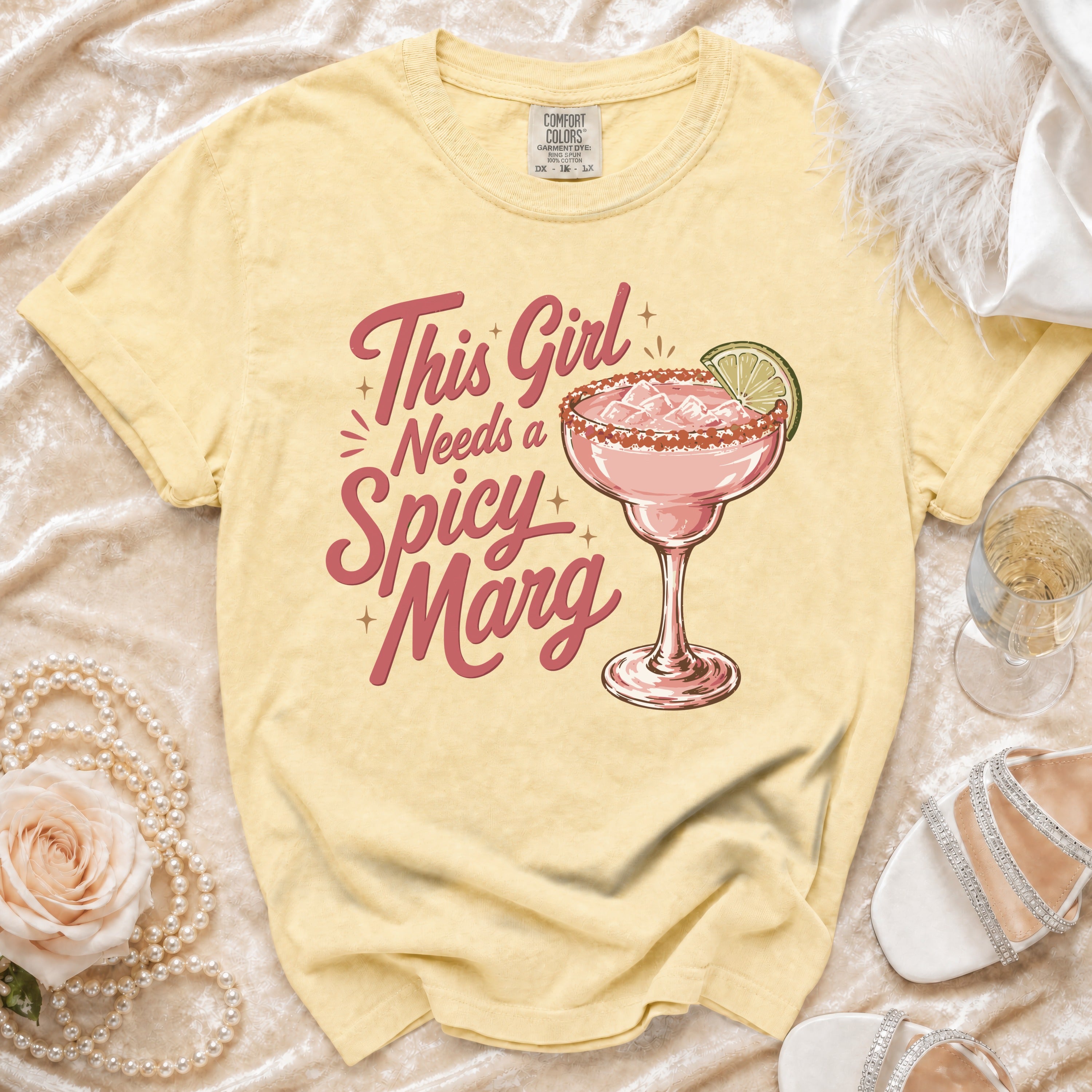 Yellow t-shirt with "This Girl Needs a Spicy Marg" text and margarita graphic.