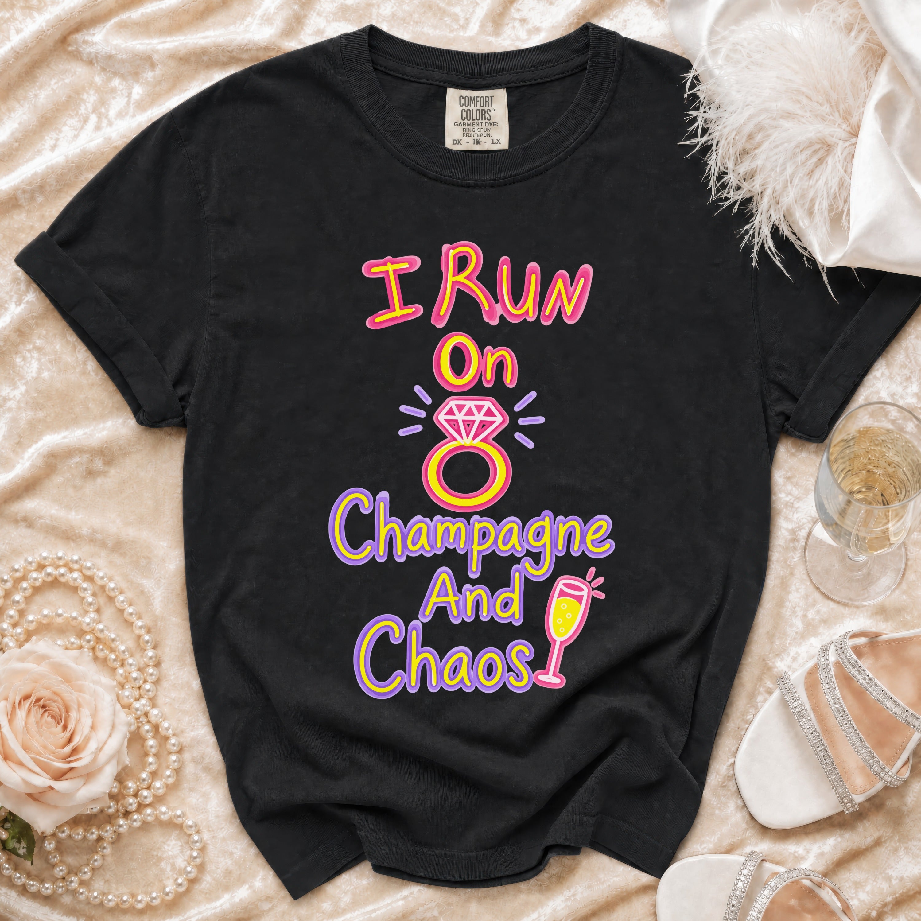 Black t-shirt with "I Run On Champagne And Chaos" graphic and a diamond ring.