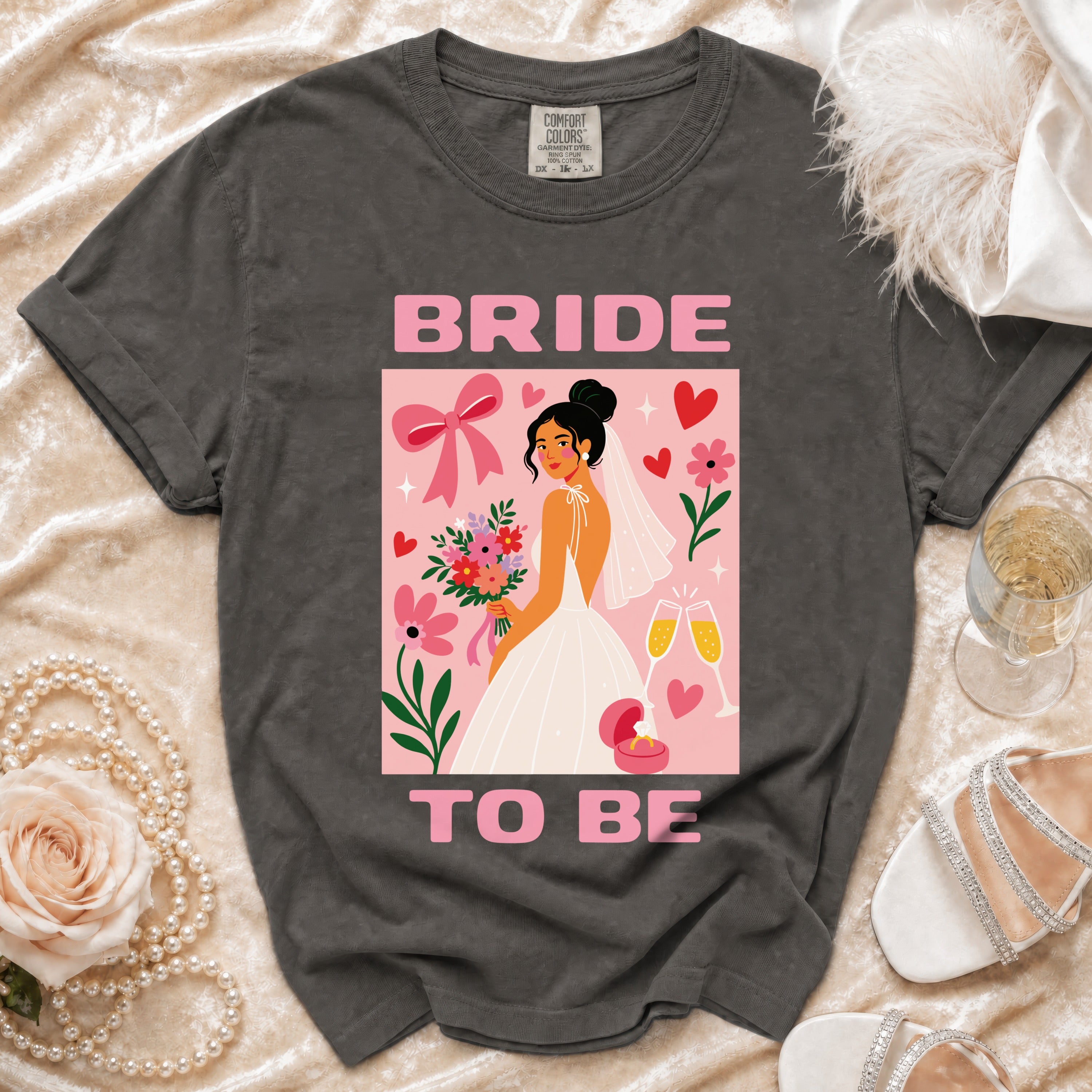 Dark grey t-shirt with a pink graphic of a bride and "BRIDE TO BE" text.