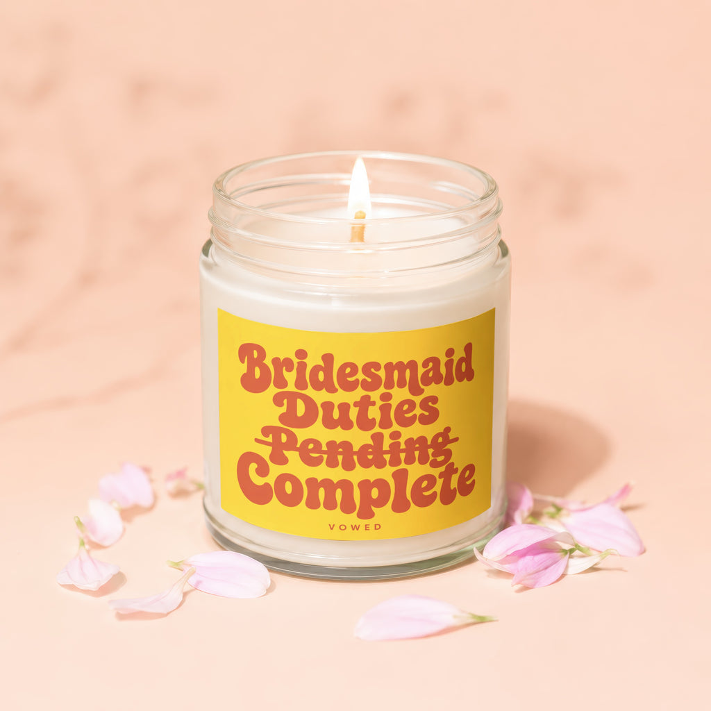 Lit candle in a glass jar with text "Bridesmaid Duties Pending Complete"