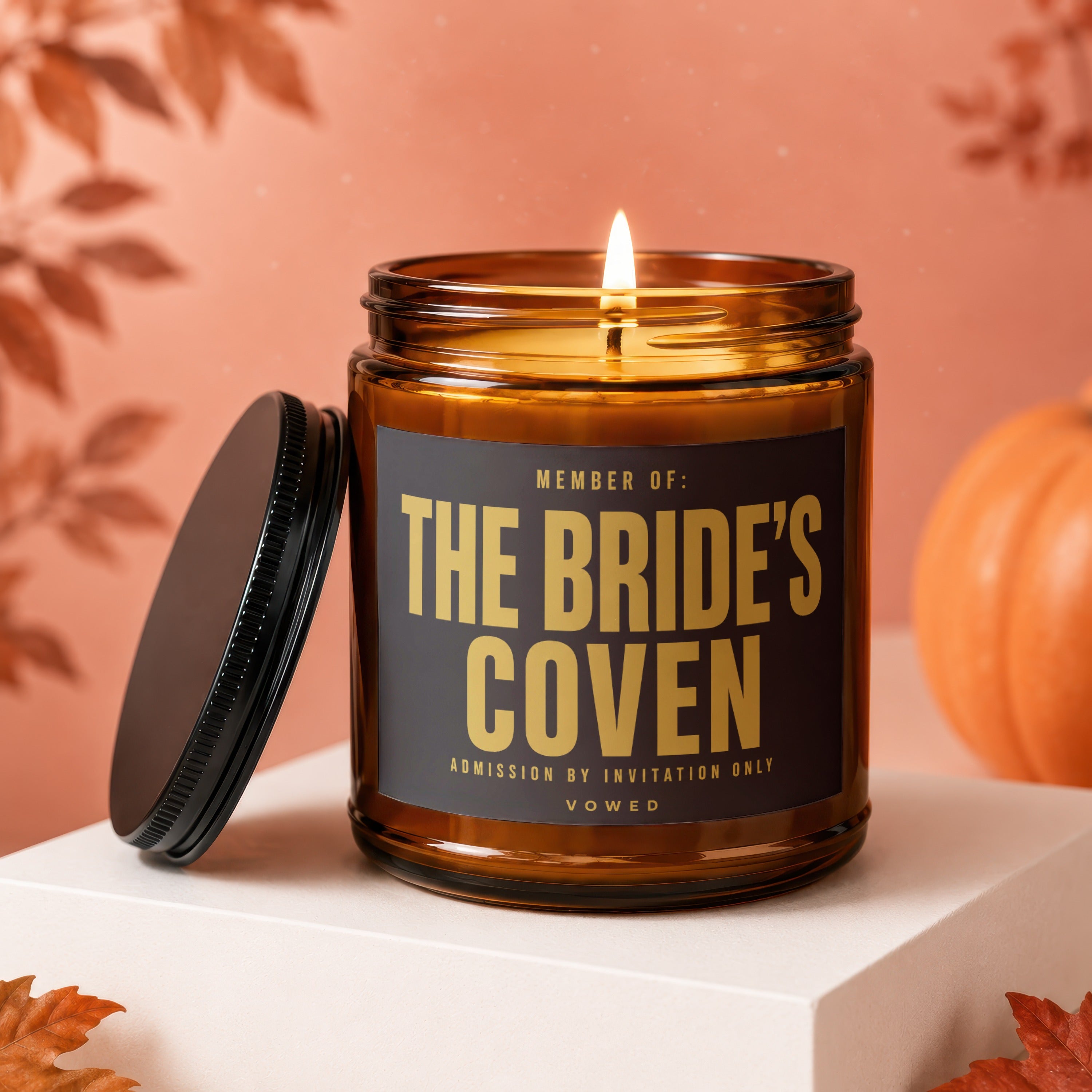 Amber candle with prominent label "THE BRIDE'S COVEN" with other text.