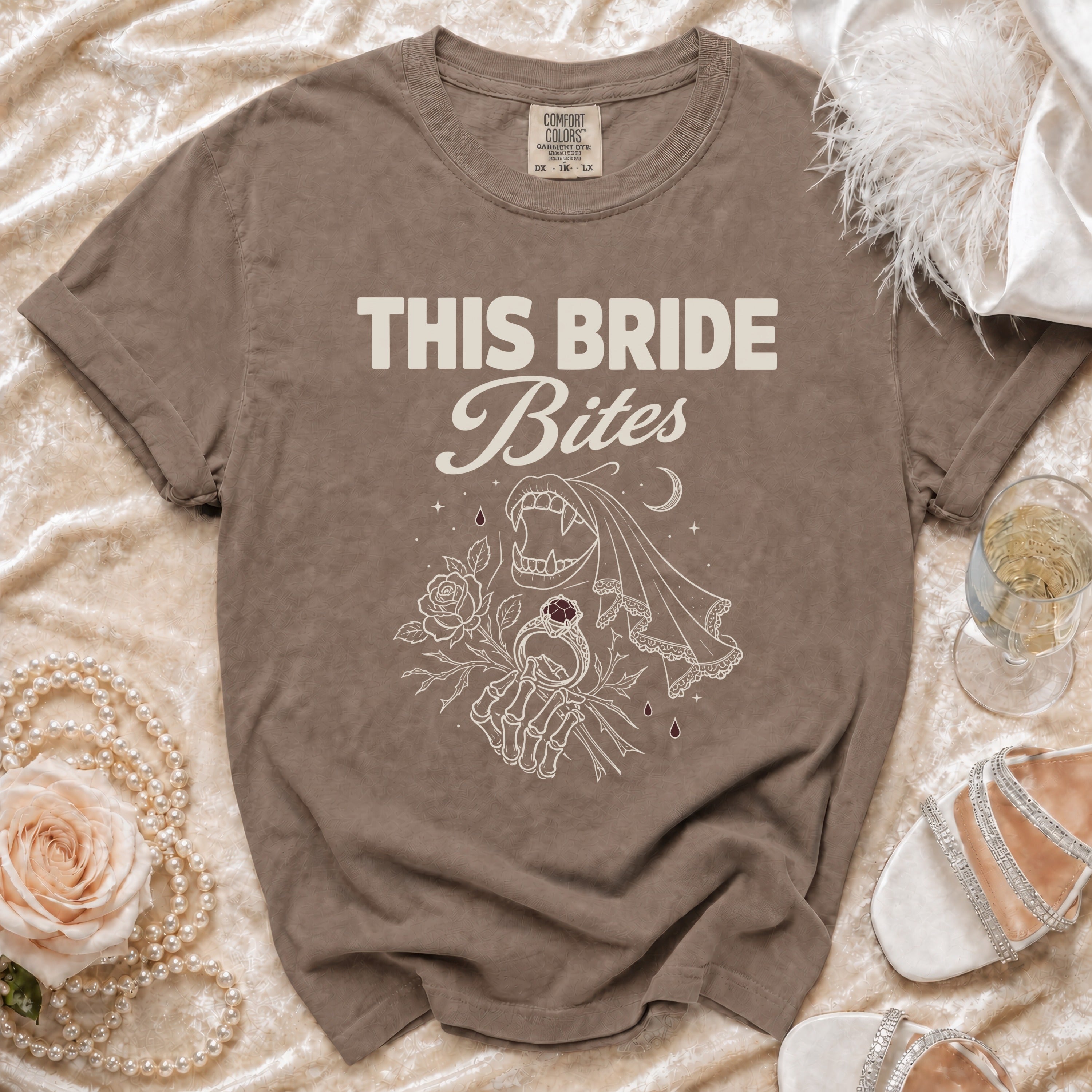 Brown t-shirt with "THIS BRIDE Bites" text and a skeleton hand holding a ring.