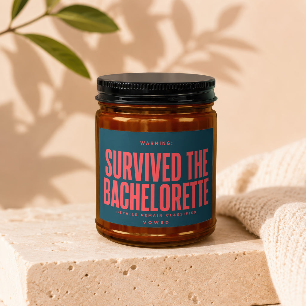 Brown glass jar with black lid, teal label saying "Survived The Bachelorette"