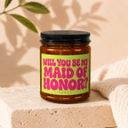 Candle with label that says "WILL YOU BE MY MAID OF HONOR?" and "VOWED".