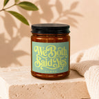 Amber jar candle with "We Both Said Yes" and "VOWED" text on a green label.