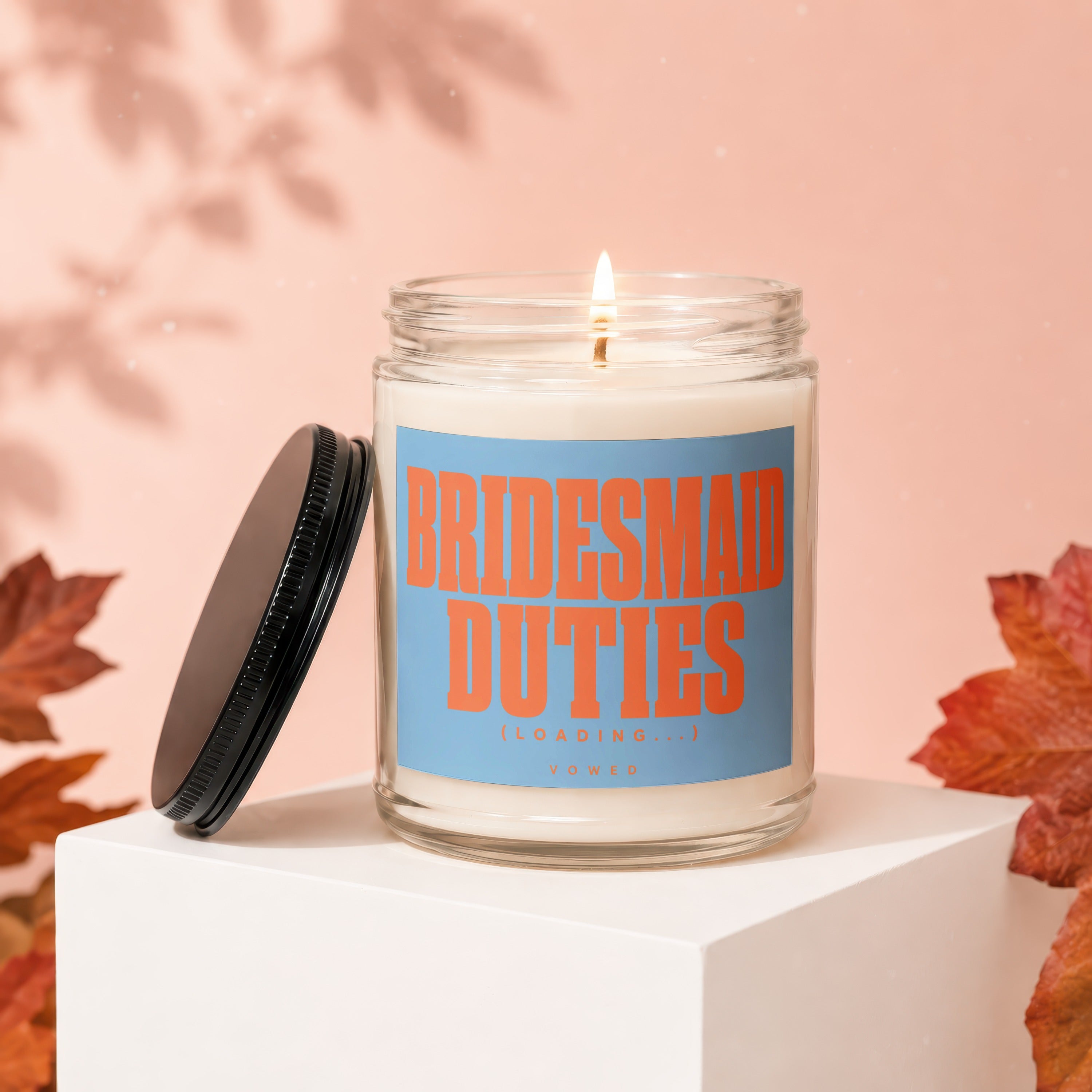 Glass candle with "Bridesmaid Duties (Loading...) VOWED" text on a blue label.