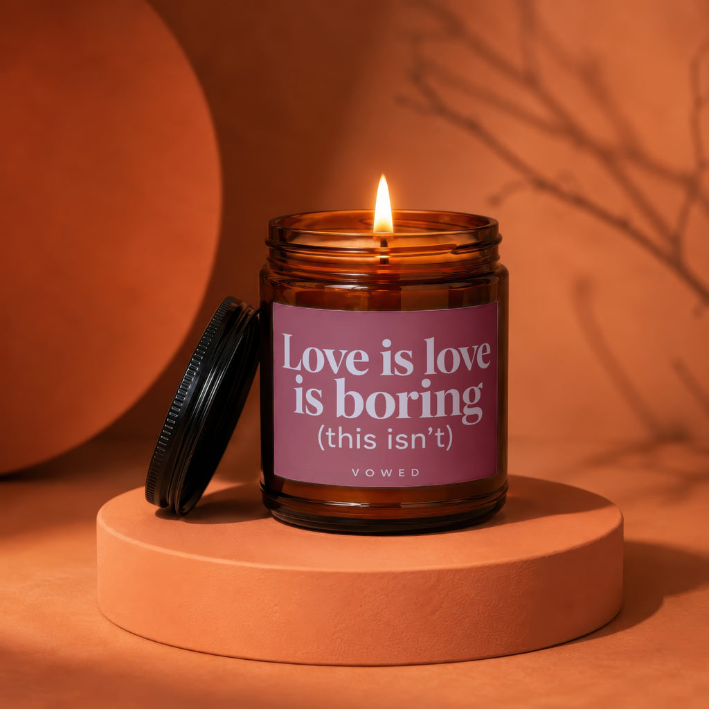 Candle with "Love is love is boring (this isn't)" text on label.