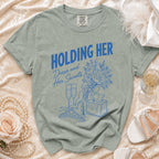 T-shirt with blue graphic reading "HOLDING HER" and "Dress and Her Secrets".
