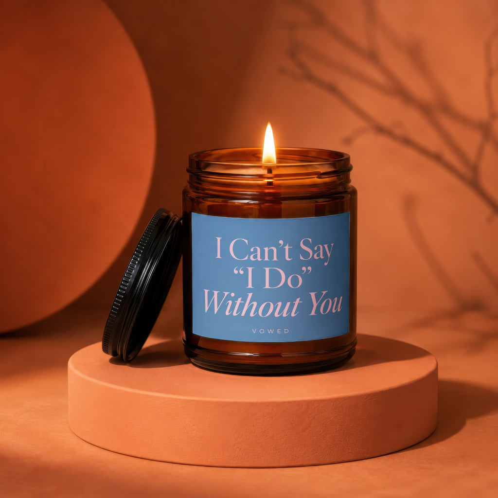 Amber glass candle with lit wick, blue label reads "I Can't Say 'I Do' Without You".