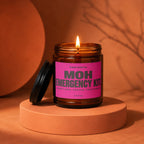 Amber jar candle with lit wick and pink label reading "MOH EMERGENCY KIT"