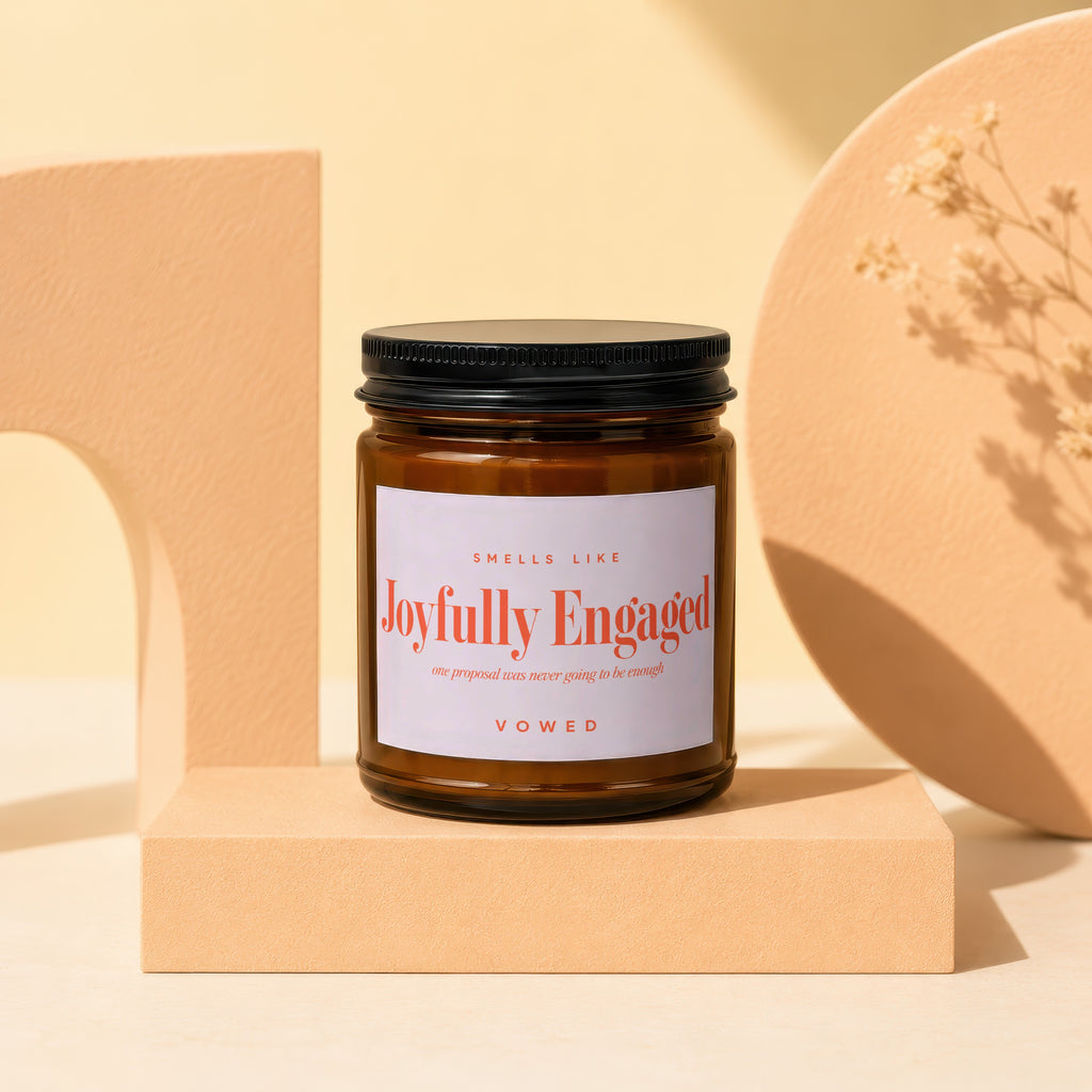 Amber jar candle, "Joyfully Engaged" scent, by Vowed, on a pedestal.