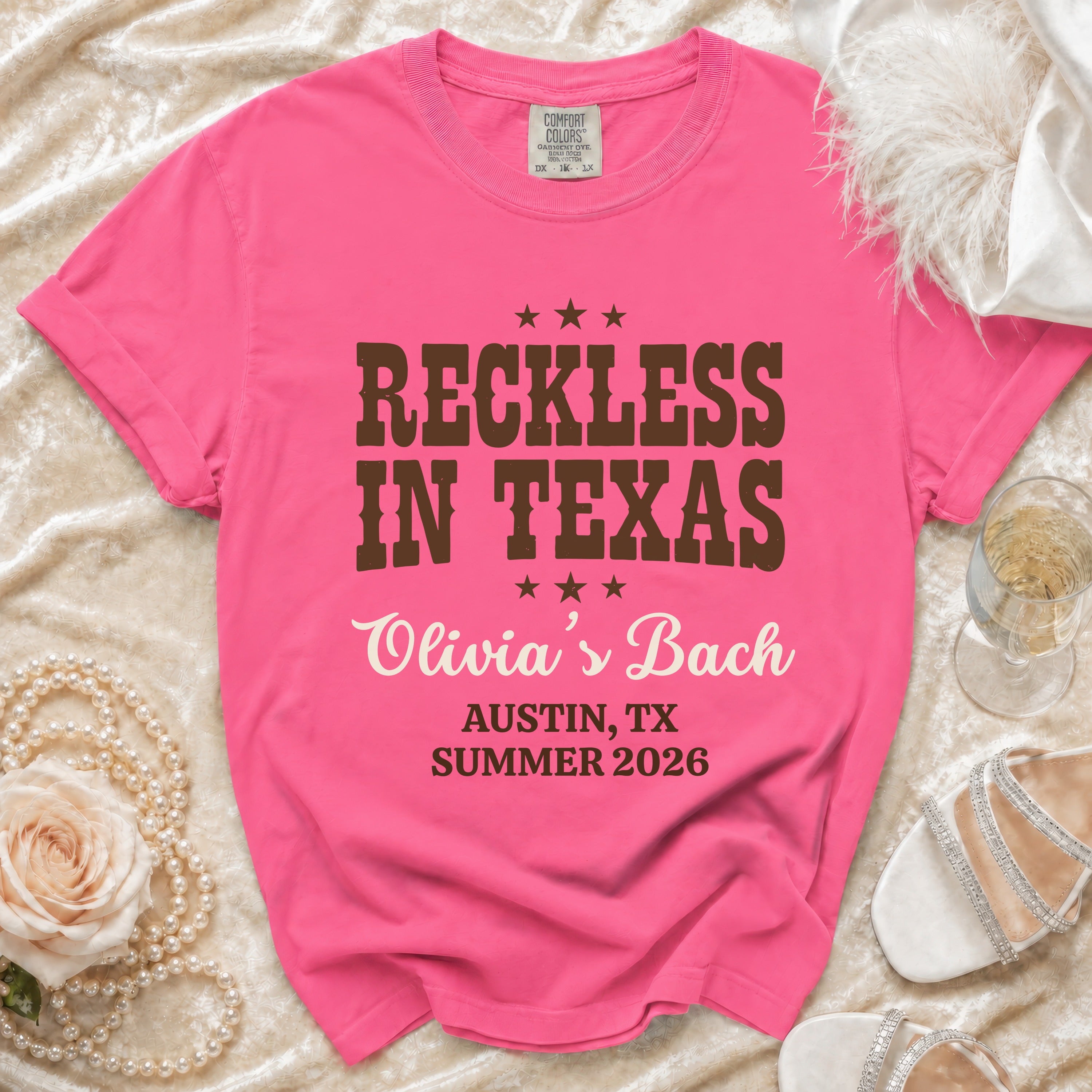 Pink t-shirt with "Reckless in Texas Olivia's Bach Austin, TX Summer 2026" text.