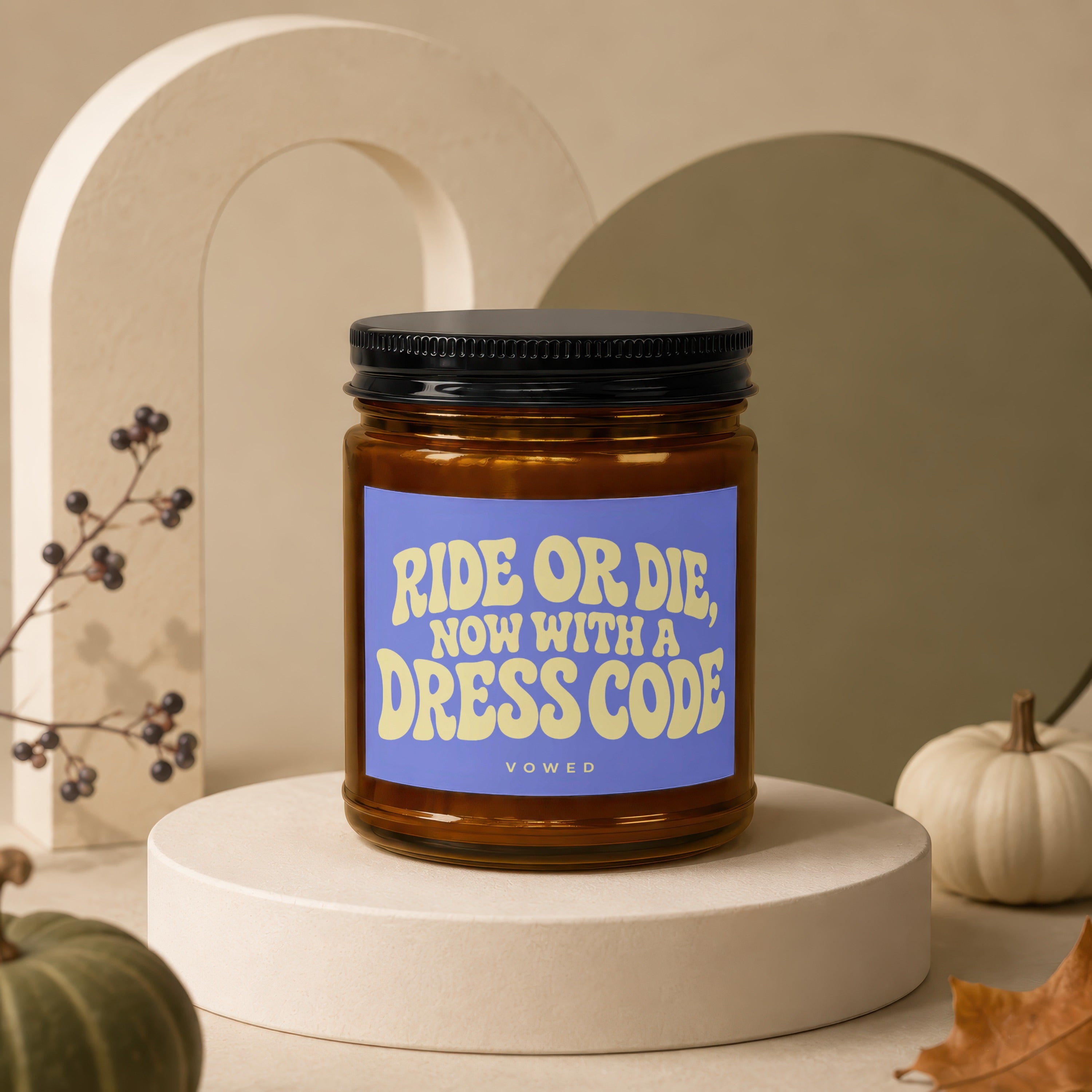 Amber jar candle with purple label reading "RIDE OR DIE, NOW WITH A DRESS CODE VOWED".