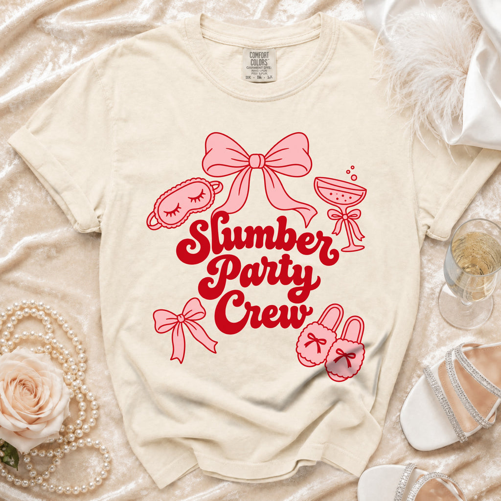 Light cream t-shirt with red "Slumber Party Crew" graphic and pink illustrations.