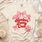 Light cream t-shirt with red "Slumber Party Crew" graphic and pink illustrations.