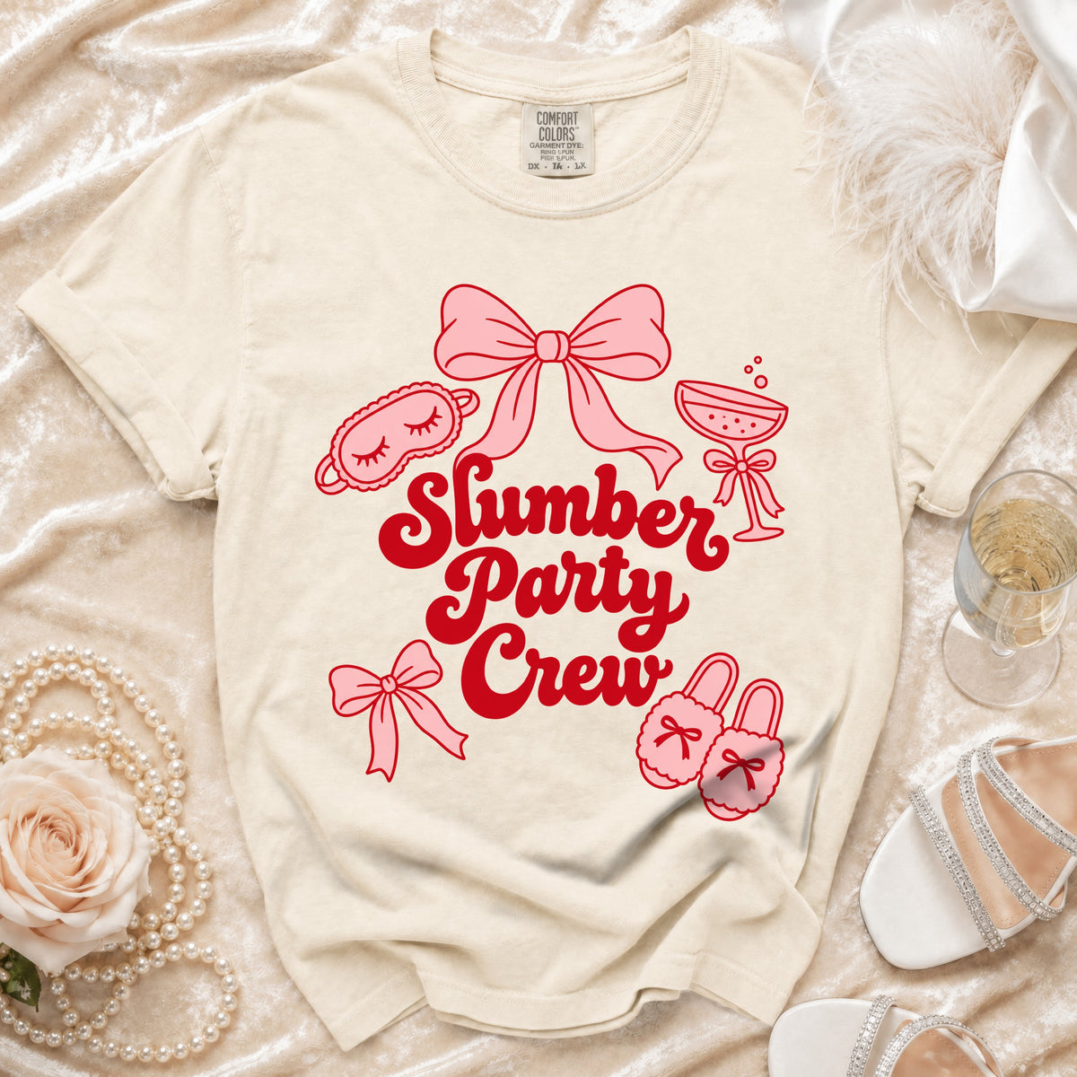 Light cream t-shirt with red "Slumber Party Crew" graphic and pink illustrations.