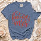 Blue t-shirt with red "future mrs" text and hearts, next to bridal accessories.
