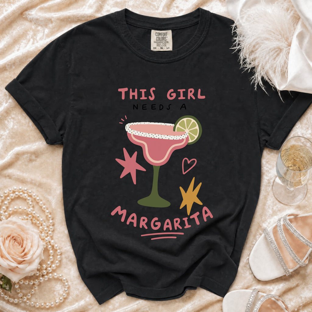 Black t-shirt with "THIS GIRL NEEDS A MARGARITA" text and margarita graphic.