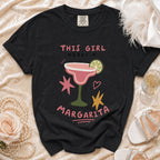 Black t-shirt with "THIS GIRL NEEDS A MARGARITA" text and margarita graphic.