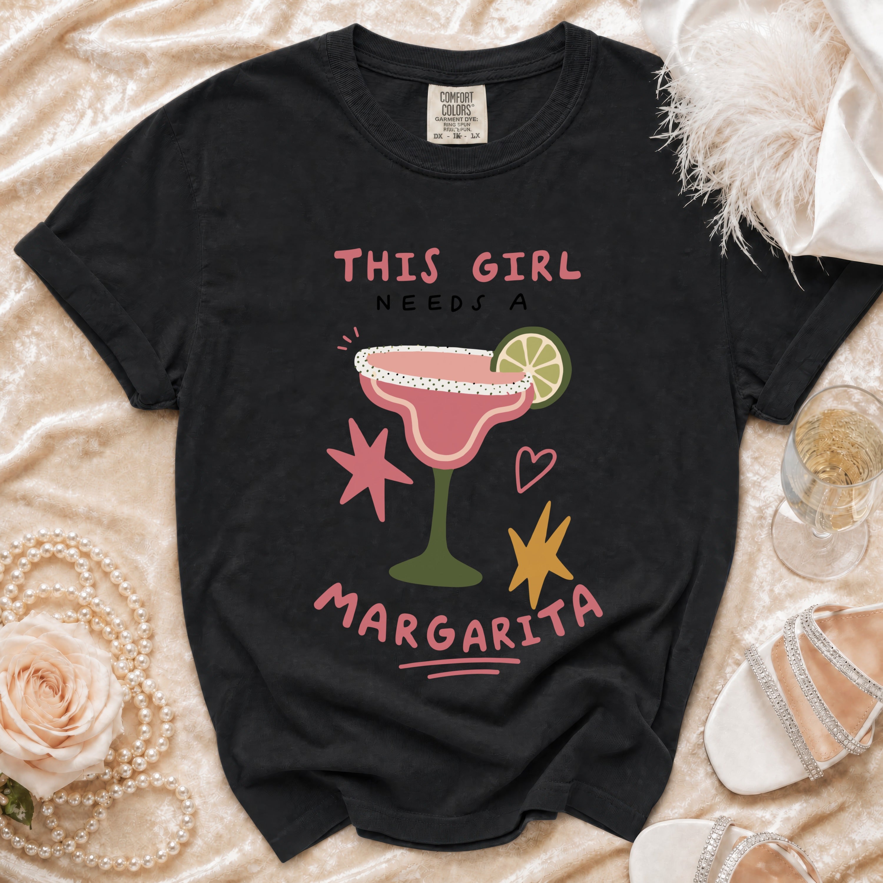 Black t-shirt with "THIS GIRL NEEDS A MARGARITA" text and margarita graphic.