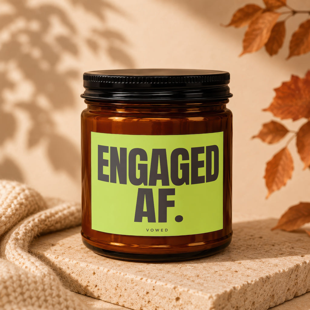 Amber candle in a glass jar with a black lid and a "ENGAGED AF. VOWED" label.