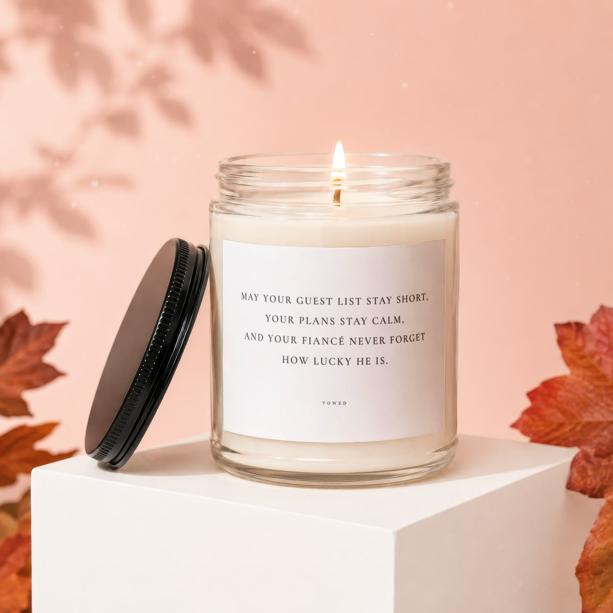 Candle with lid removed, featuring text "May your guest list stay short."