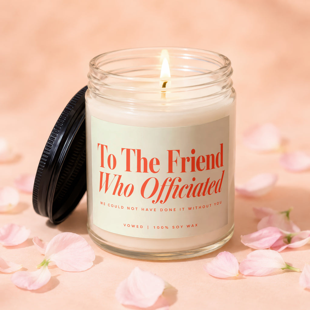 Candle with lit wick and sentiment "To The Friend Who Officiated" on label.