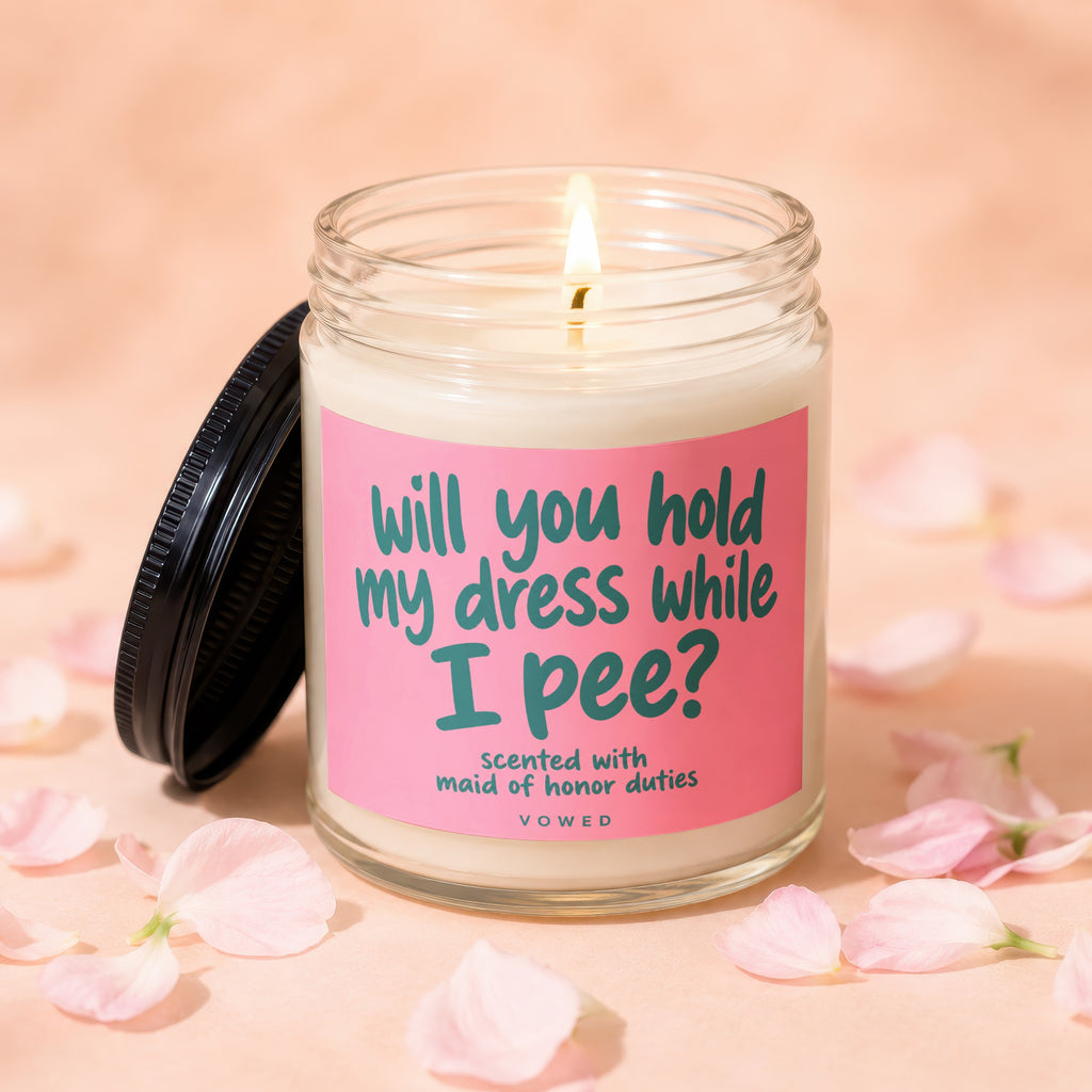 Candle with text "will you hold my dress while I pee?" and "VOWED".