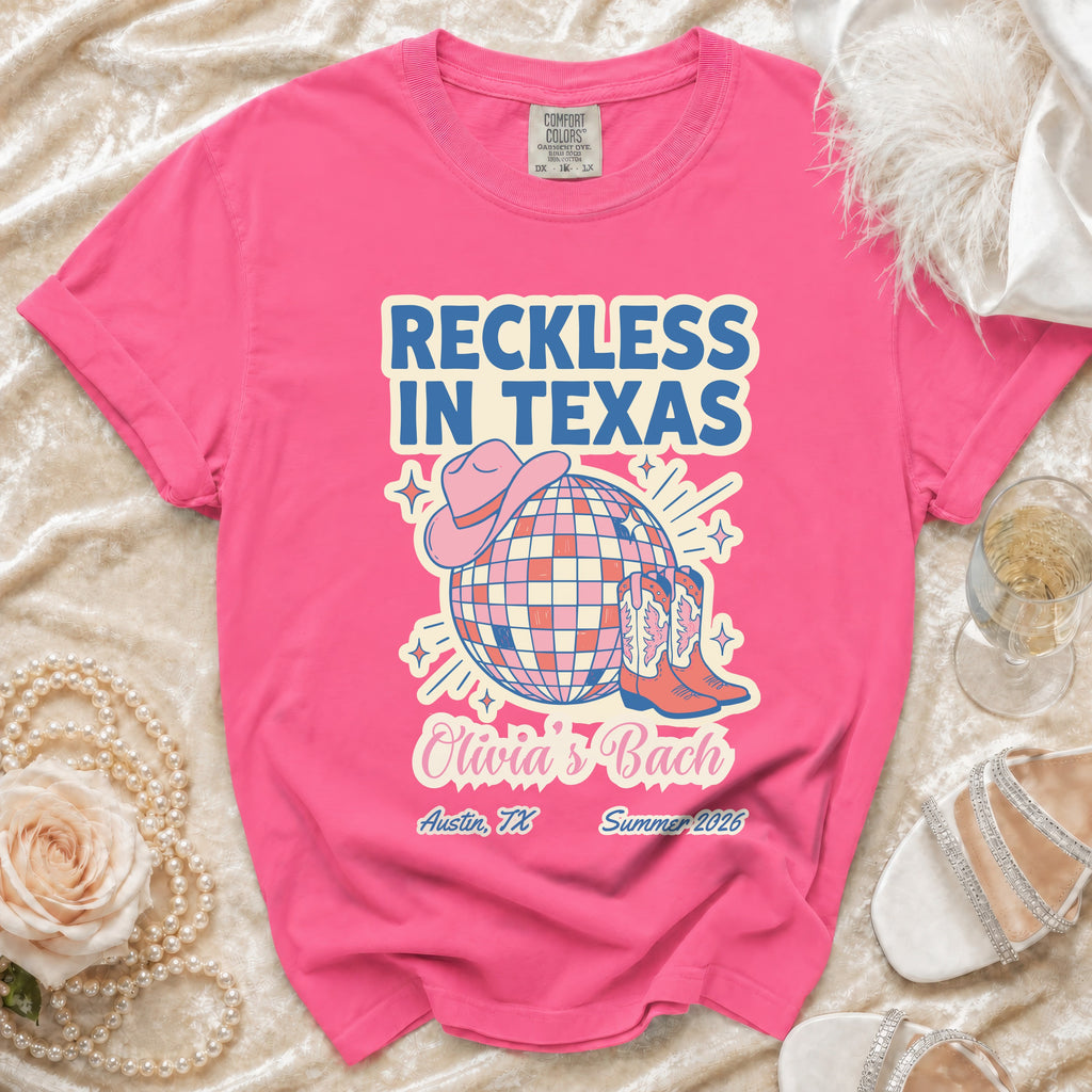 Pink t-shirt with "Reckless in Texas" and "Olivia's Bach" text, disco ball, cowboy hat, and boots.