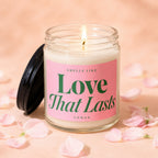 Lit candle in a glass jar with a pink label reading "Smells Like Love That Lasts Vowed".