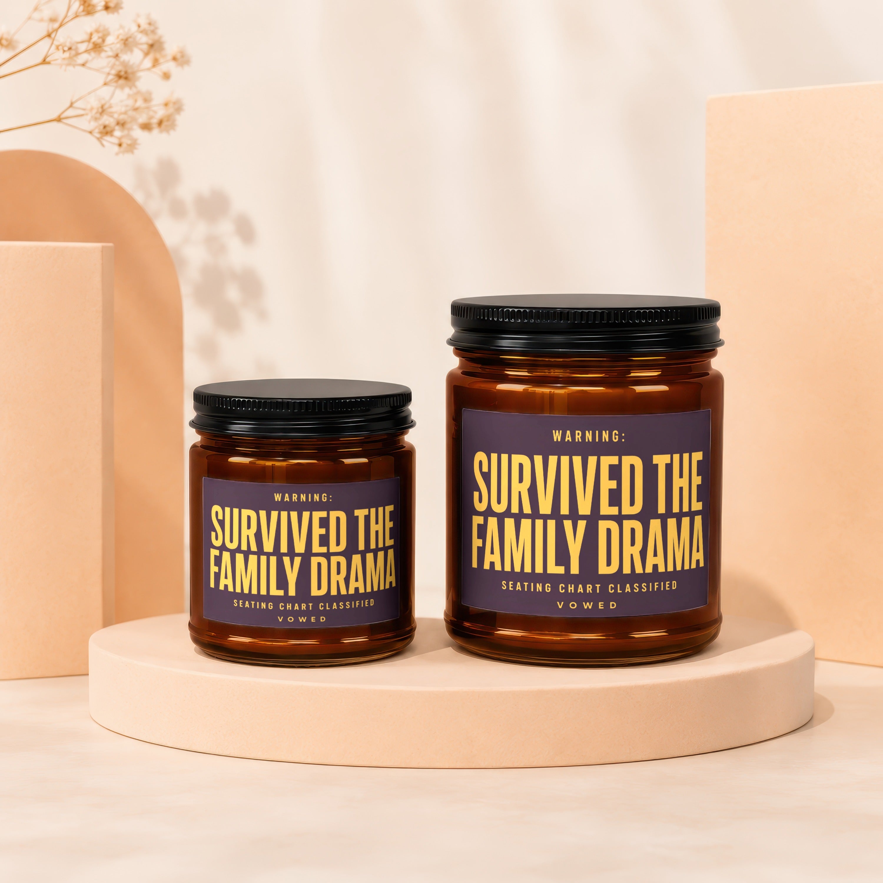 Two amber candles with purple labels reading "Survived the Family Drama."