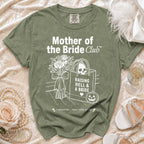 Green t-shirt with "Mother of the Bride Club" graphic, skull bag, and text.